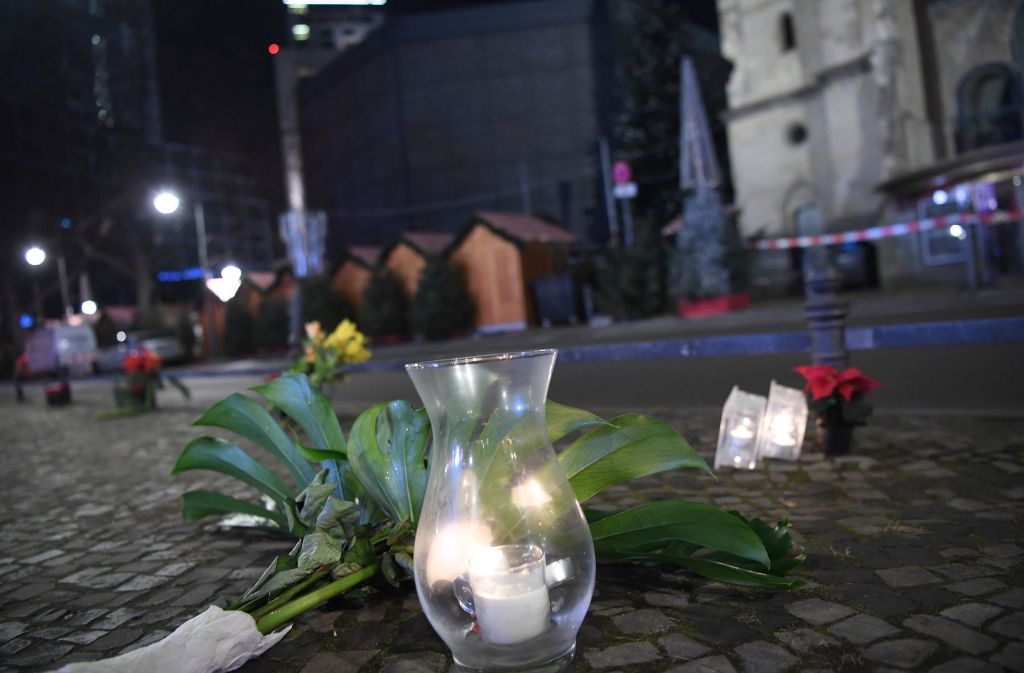 Erste Zeichen der Trauer: Vor dem Weihnachtsmarkt, auf dem am Montagabend ein Anschlag mit einem Lastwagen verübt worden ist, sind Blumen und Kerzen niedergelegt worden.