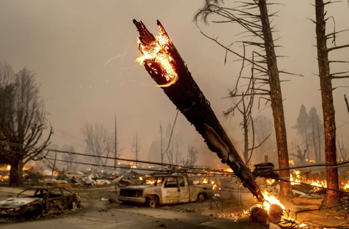 Ein Strommast wird vom Feuer eines Waldbrandes, dem sogenannten Dixie-Feuer erfasst und umgeknickt.