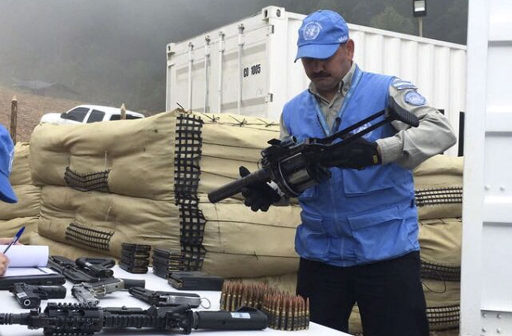 Ein Mitarbeiter der Vereinten Nationen kontrolliert eine Waffe, die von Farc-Rebellen im Zuge des Friedensprozesses ausgehändigt wurde.