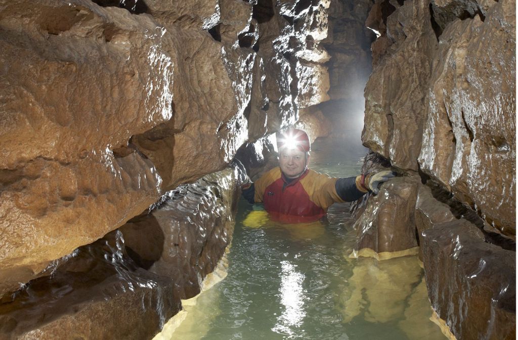 Ein Höhlenforscher der Arge Grabenstetten watet durch das brusttiefe, eiskalte Wasser der Elsach, die durch die Falkensteiner Höhle fließt (Archivbild).