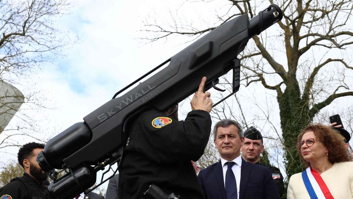 Das etwas andere Kampfgerät: Dem französischen Innenminister Gerald Darmanin (M.) wird in Beynes eine Anti-Drohnen-Waffe vorgeführt.