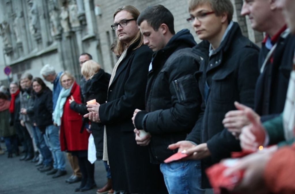 Bürger nehmen am Samstag in Köln an einer Menschenkette teil.