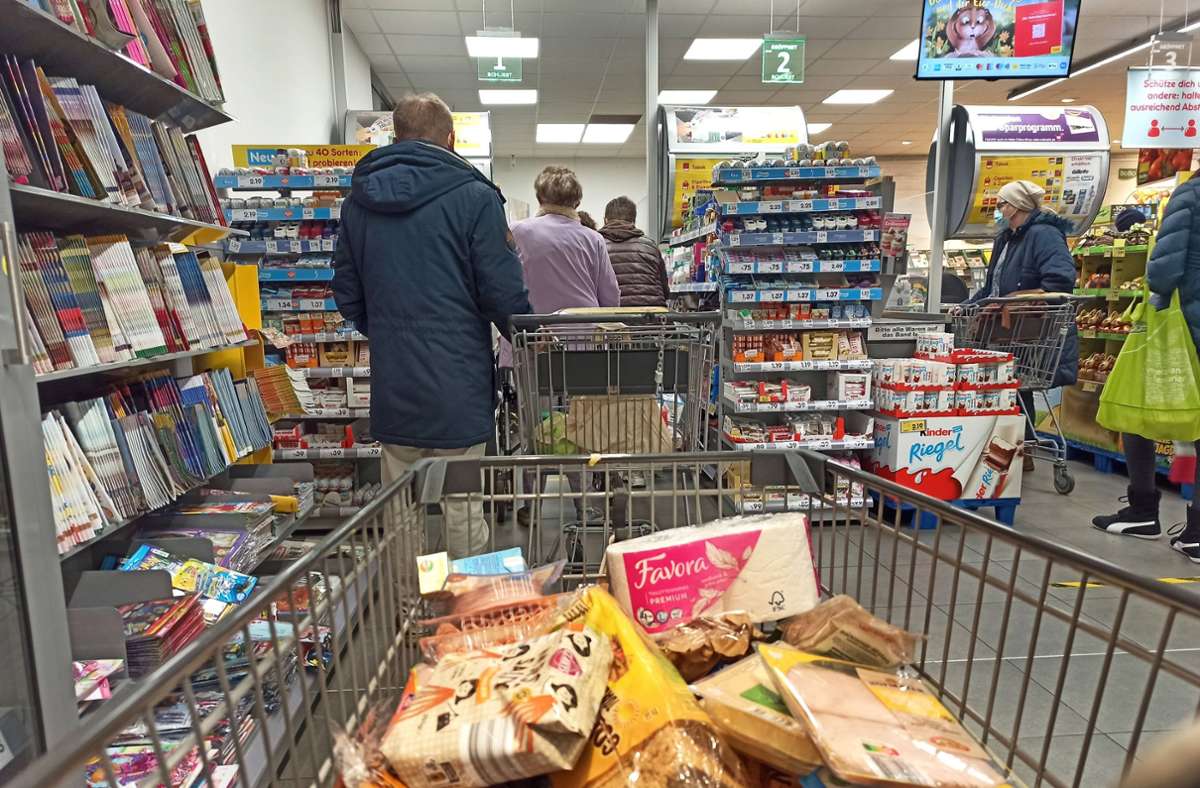 Im Kassenbereich eines Supermarkts stauen sich die Kunden (Symbolbild) Foto: IMAGO/Martin Wagner