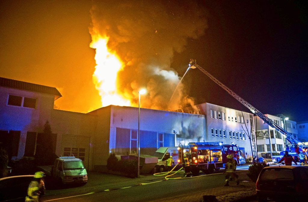 Meterhohe Flammen ragen aus dem Gewerbeanwesen in die Höhe.