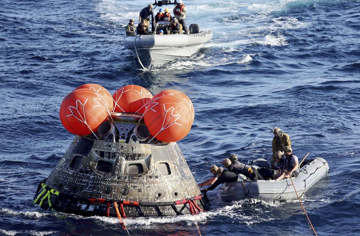 Taucher der US-Marine sichern die Orion-Kapsel der Nasa während der Bergungsarbeiten, nachdem sie zum Abschluss eines Testflugs im Pazifik vor Mexiko gelandet ist.