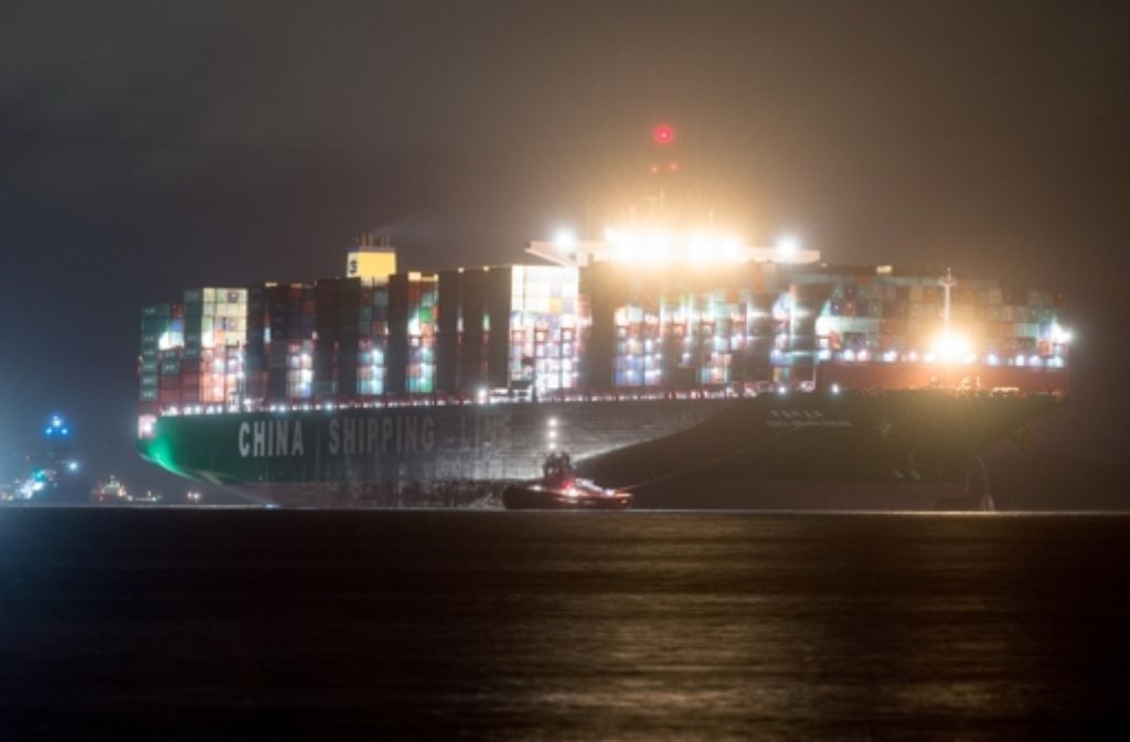 Mehrere Schlepper haben den Containerfrachter „CSCL Indian Ocean“ der Reederei China Shipping Lines wieder in zurück in die Fahrrinne der Elbe vor Grünendeich bei Stade (Niedersachsen) gezogen und begleiten das Schiff nun bei starkem Regen in den Hafen von Hamburg.