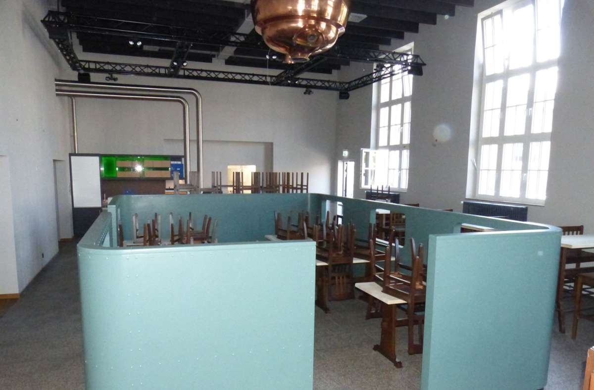 Durch die hohen Fenster ist das Restaurant sehr hell. Die Tische sind teilweise durch eine Konstruktion abgetrennt, die an ein Zugabteil erinnert, unter der Decke hängt ein originaler Sudkessel.