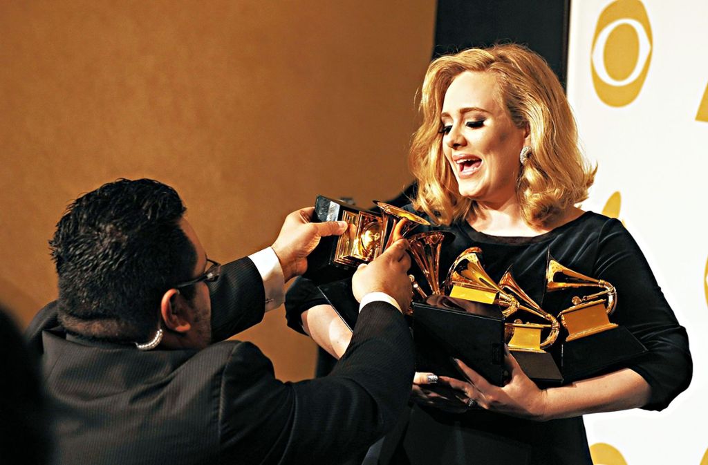 Die Sängerin Adele hat mittlerweile so viele Grammys, dass sie nicht alle auf einmal halten kann.