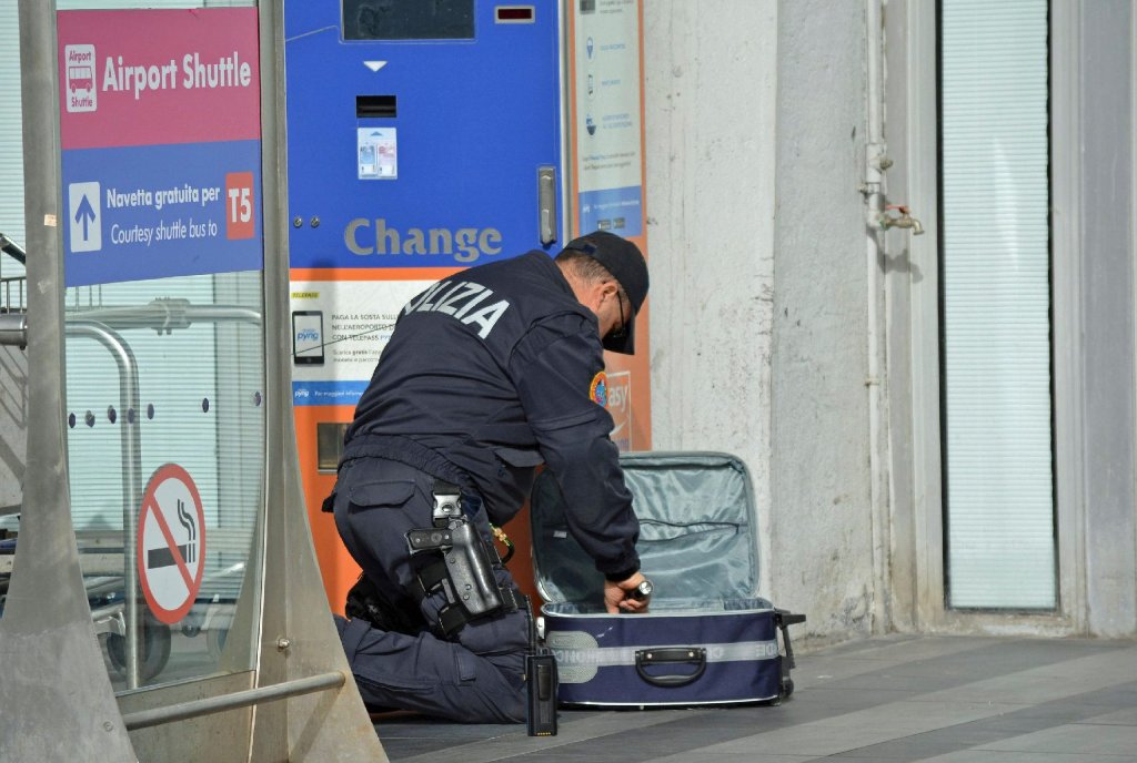 Ein Polizist durchsucht einen Koffer.