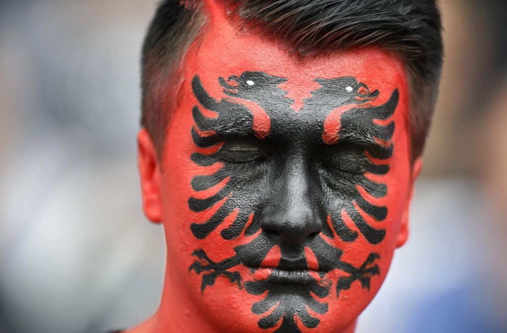 Ein albanischer Fan mit aufwendiger Gesichtsbemalung.