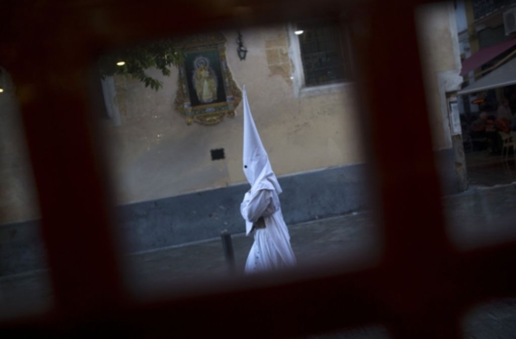 Ein maskierter „Nazareno“ aus Sevilla auf dem Weg in die Kirche.