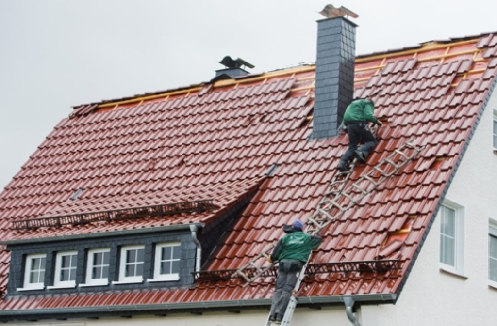 Dachdecker reparieren ein vom Sturm teilweise abgedecktes Dach eines Einfamilienhauses in Coppenbrügge im Landkreis Hameln (Niedersachsen).
