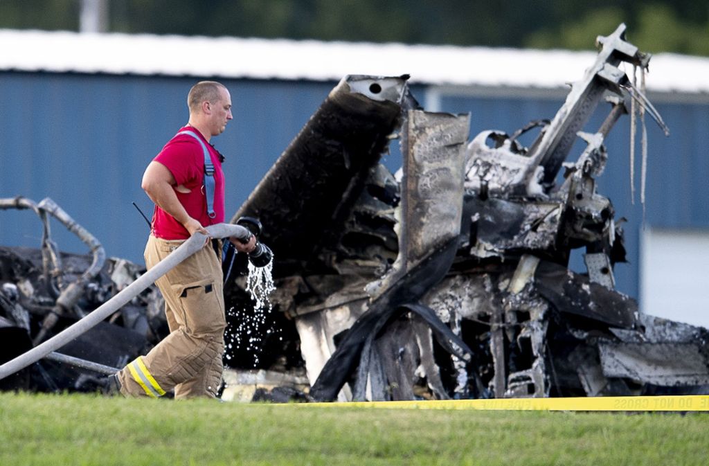 Ein Feuerwehrmann löscht das Wrack des Flugzeugs, in dem Dale Earnhardt Jr. seine Frau und seine Tochter waren.