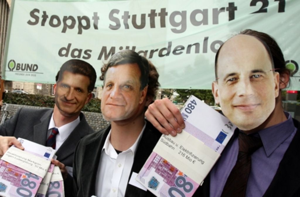 Mitglieder des BUND demonstrieren im Oktober 2006 vor dem Stuttgarter Hauptbahnhof mit Masken des damaligen Ministerpräsidenten Oettinger, des damaligen Bahnchefs Mehdorn und des damaligen Bundesverkehrsministers Tiefensee anlässlich eines Spitzengesprächs in Berlin.