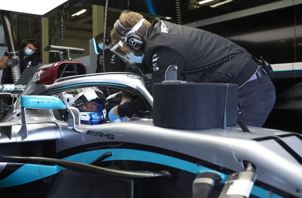 Der Mechaniker setzt das Lenkrad ein, gleich darf Lewis Hamilton raus auf die Strecke.