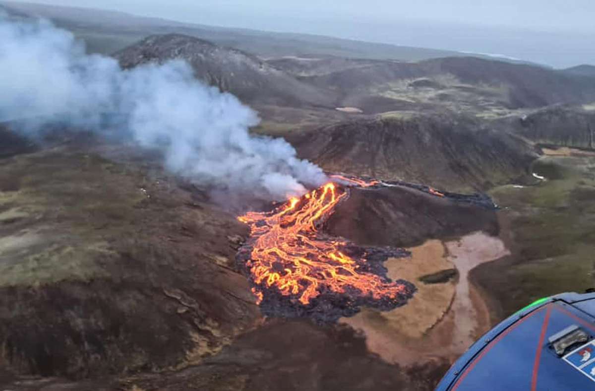 Eine Luftaufnahme der Küstenwache zeigt wie Lava aus dem Vulkan Fagradalsfjall fließt und Rauch aufsteigt.