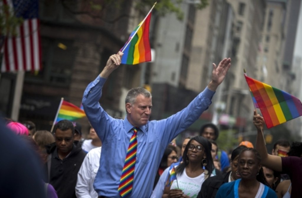 Auch der New Yorker Bürgermeister Bill de Blasio schwingt ein Regenbogenfähnchen auf der Gay-Pride-Parade.
