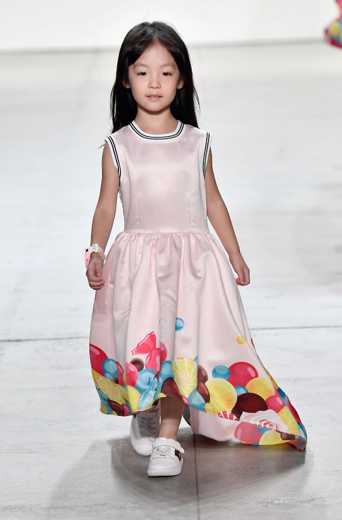 Das kleine Mädchen läuft mit einem rosa Kleid über den Laufsteg in New York.