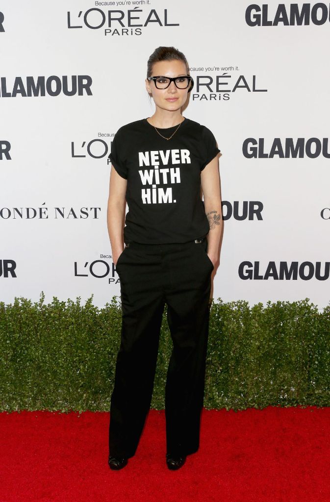 Designerin Brandon Milbradt nutzt den roten Teppich, um ihr Statement zum Wahlergebnis abzugeben. Zur schwarzen Hose kombiniert sie ein schlichtes T-Shirt mit der Aufschrift „Never With Him“, was auf Deutsch „Niemals mit ihm“ bedeutet.