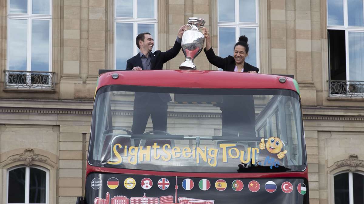 Célia Šašić und Philipp Lahm bringen den Pokal auf den Schlossplatz.