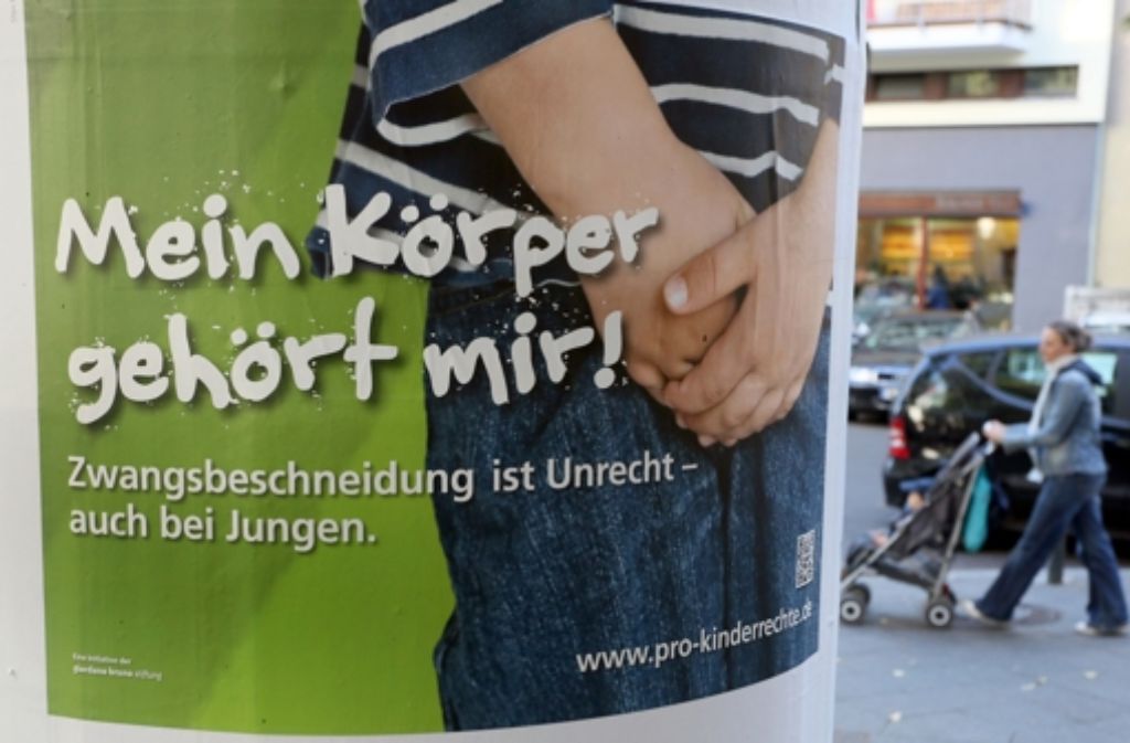 Kinderschützer demonstrieren in Berlin mit einem Plakat gegen die Beschneidung. Foto: dpa