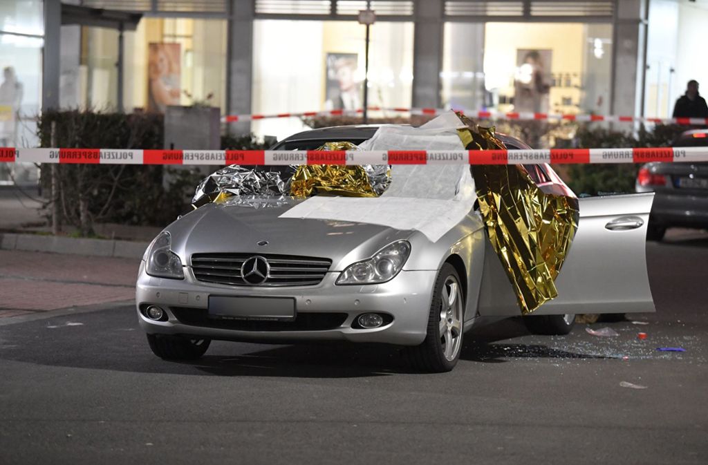 Ein Auto ist mit Thermofolie abgedeckt, neben dem Wagen liegen Glassplitter, der Tatort ist mit Polizei-Band abgesperrt.