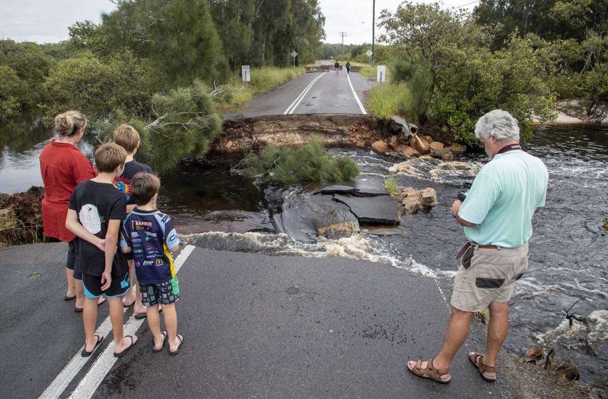 Eine Straße, 200 Kilometer entfernt von Sydney, wird unterspült und bricht auseinander.