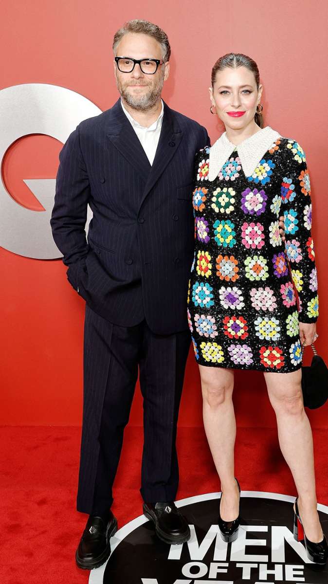 Der Schauspieler Seth Rogen mit seiner Frau Lauren Miller – er in einem klassischen schwarzen Anzug, sie in einem kurzen, bunt gemusterten Kleid mit Bubikragen.