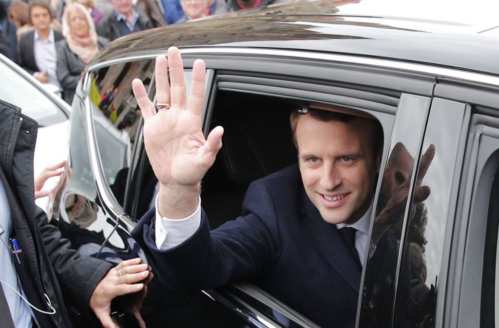 Emmanuel Macron winkt seinen Anhängern und den Fotografen zu.