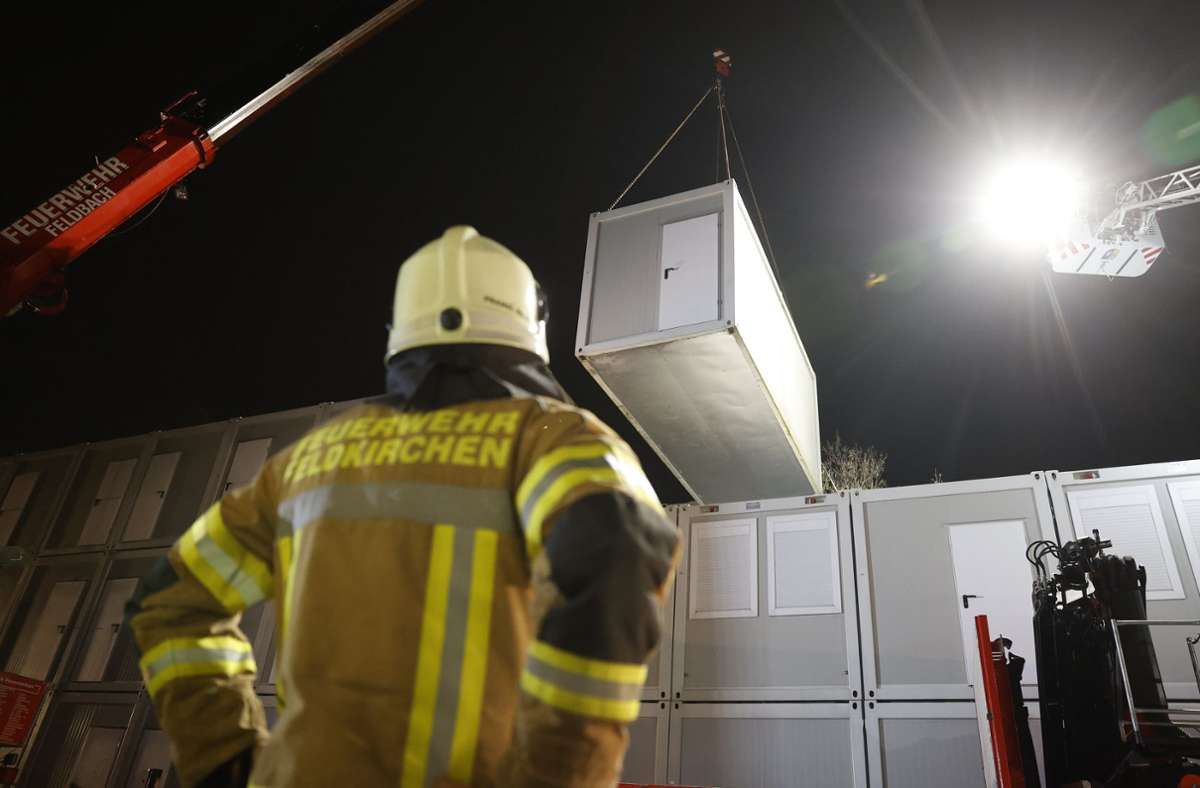 Ein Feuerwehrmann steht vor Wohncontainern im österreichischen Graz. Sie werden an die von den Erdbeben heimgesuchten Regionen Kroatiens geliefert.