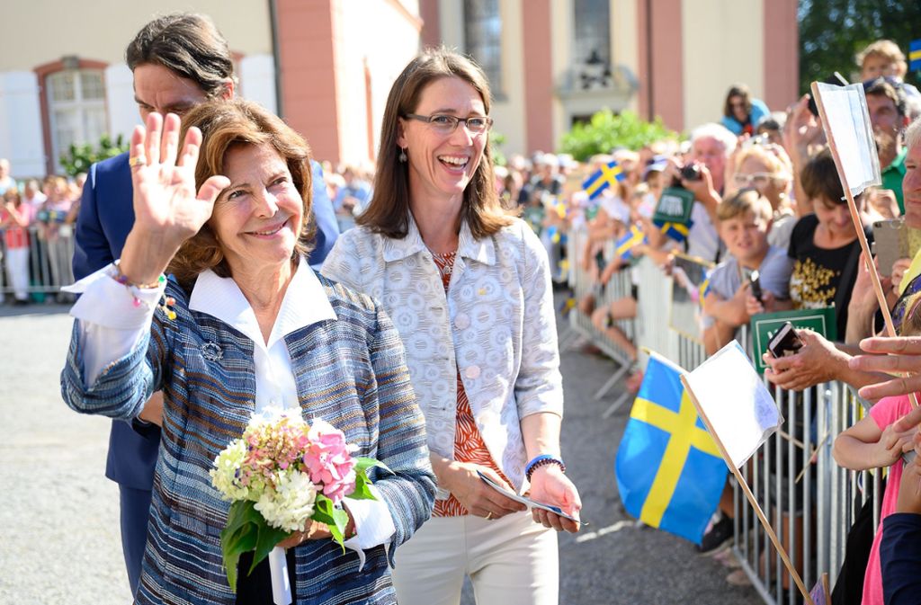 Schwedens Königin Silvia (vorne) grüßt das Publikum auf der Mainau.