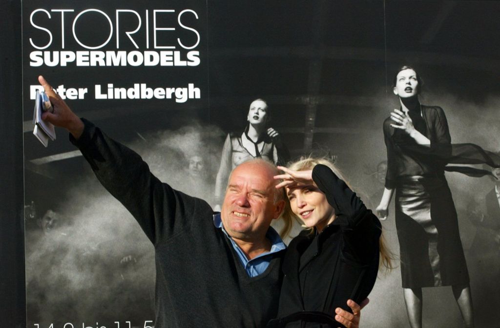 Lindbergh und Model Nadja Auermann stehen vor seinem Plakat „Invasion 2000“ der Ausstellung „Stories - Supermodels“.