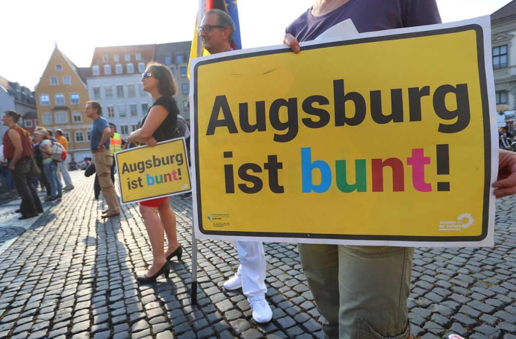 Teilnehmer der Kundgebung „Für ein solidarisches Augsburg - gemeinsam gegen Rassismuss“ demonstrieren auf dem Augsburger Rathausplatz.