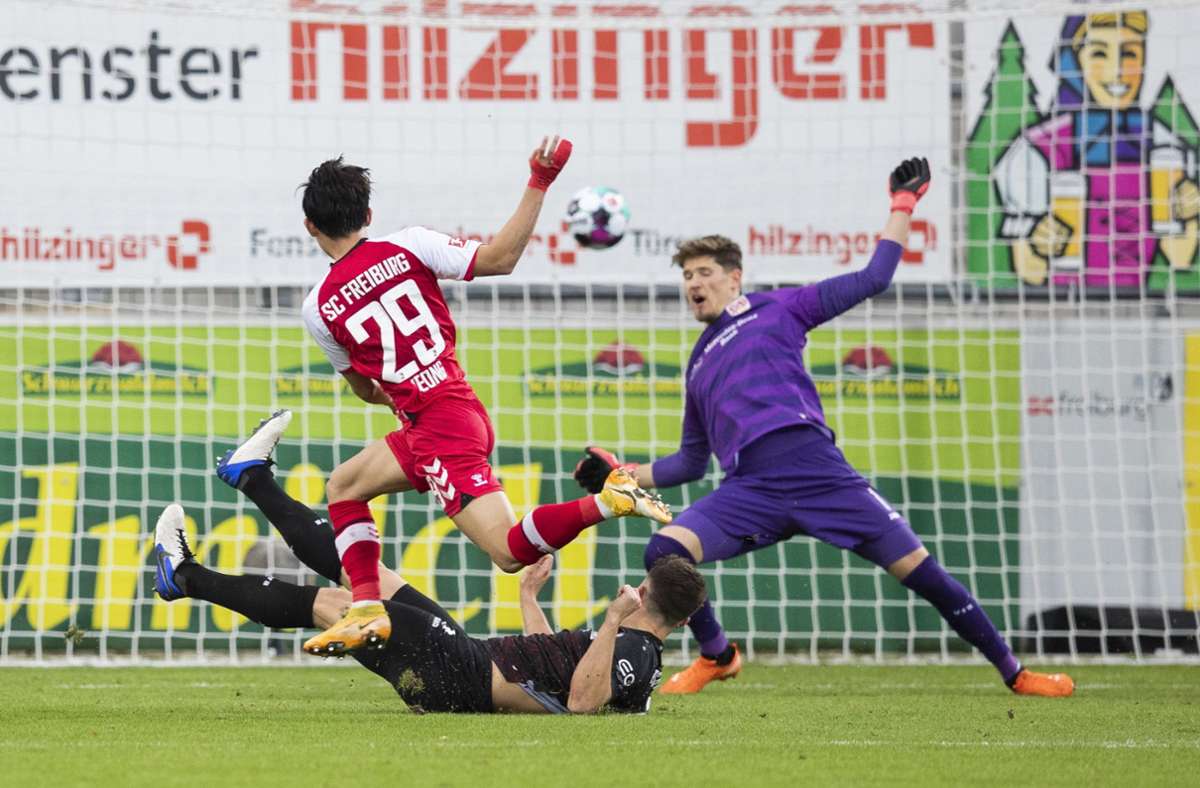 Woo-yeong Jeong schießt die Freiburger in der 37. Spielminute in Führung. Abwehrspieler Marc Oliver Kempf und Torwart Gregor Kobel können das Tor nicht verhindern.