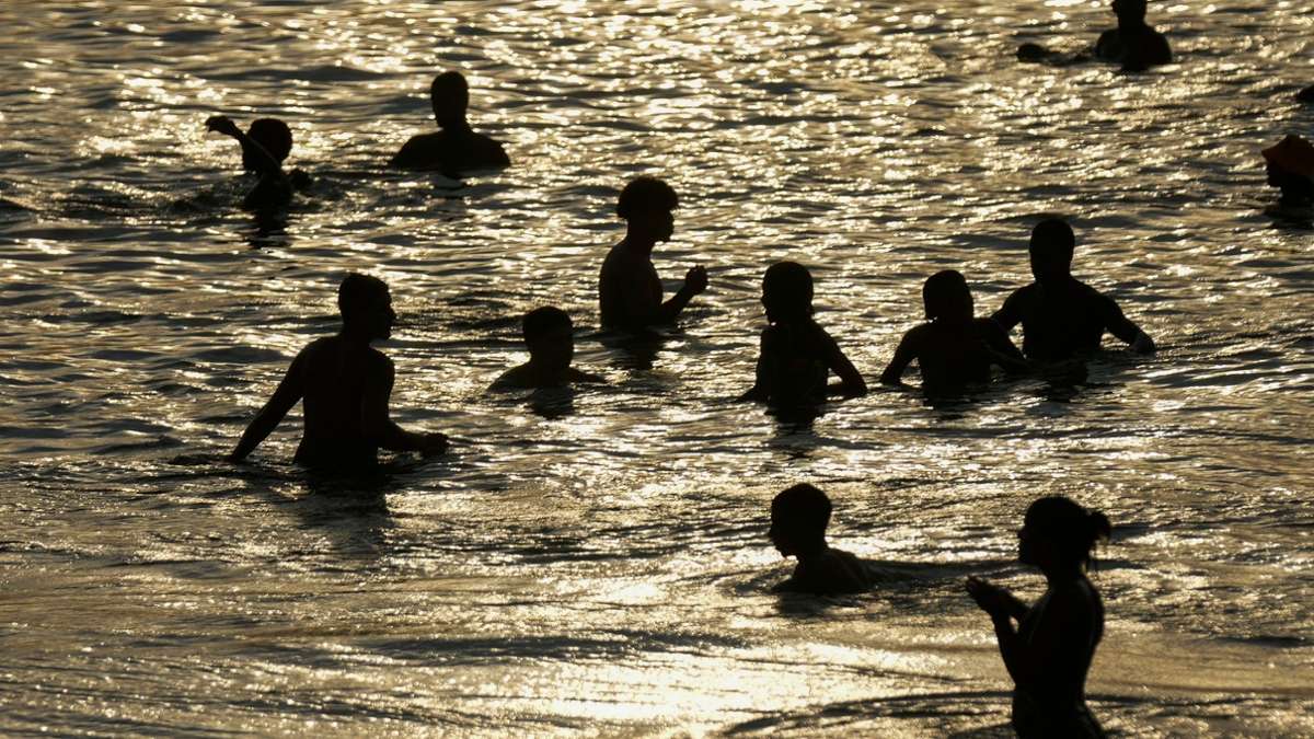 Während einer Hitzewelle tummeln sich Menschen im seichten Wasser des Strandes von Arpoador in Rio de Janeiro.