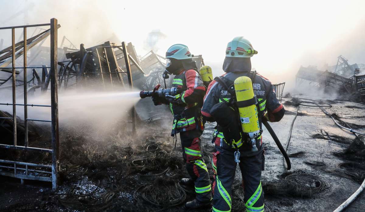 Einsatzkräfte der Feuerwehr stehen auf dem Gelände eines Reifengroßhändlers Göggel und löschen das Feuer. Ersten Schätzungen zufolge beläuft sich der entstandene Sachschaden auf mehrere Millionen Euro.