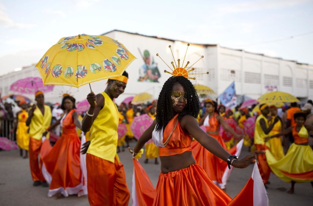 Tanzgruppen in bunten Gewändern ziehen durch die Straßen.