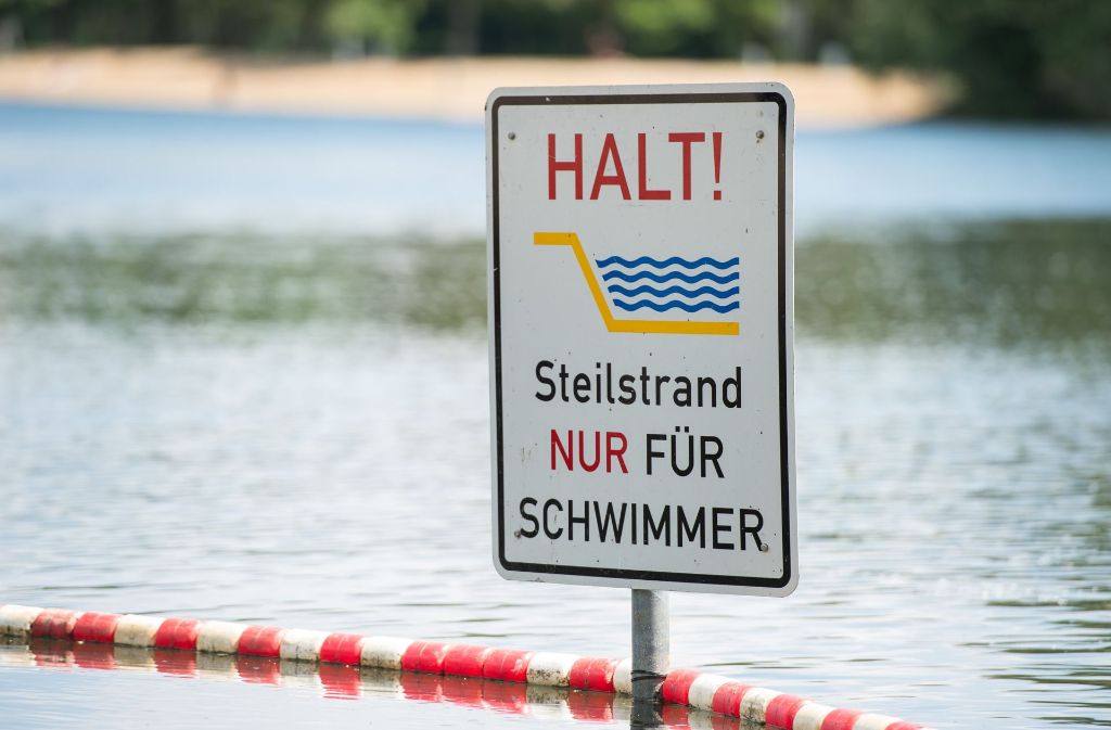 Ein Schild mit der Aufschrift „Halt Steilstrand nur für Schwimmer“ steckt im Silbersee in Hannover (Niedersachen). Ein heißer Sommertag am See macht viel mehr Spaß, wenn man richtig gut schwimmen kann.