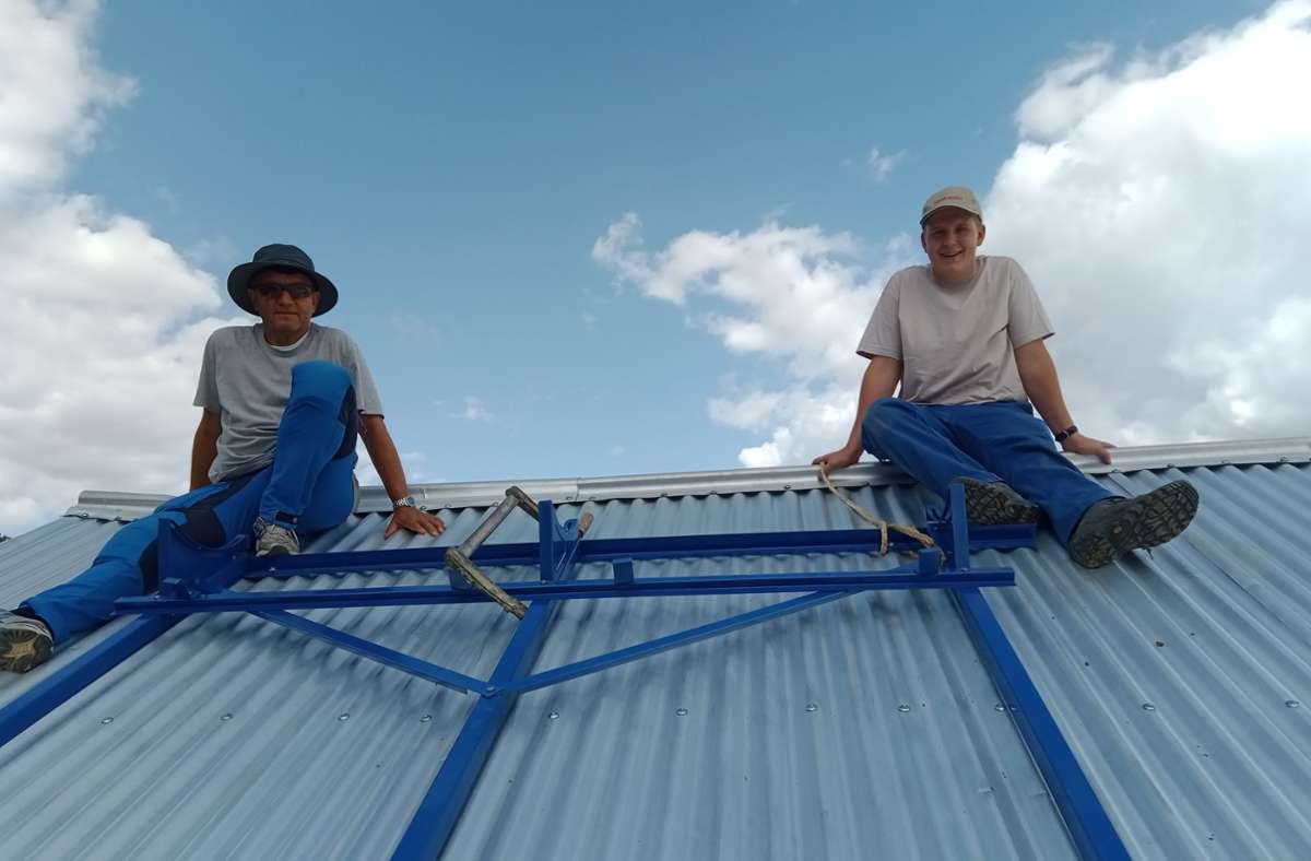Rolf Exler (links) und sein Kollege Rune Bürgin installieren den Rahmen für die Solaranlage auf dem Schuldach.