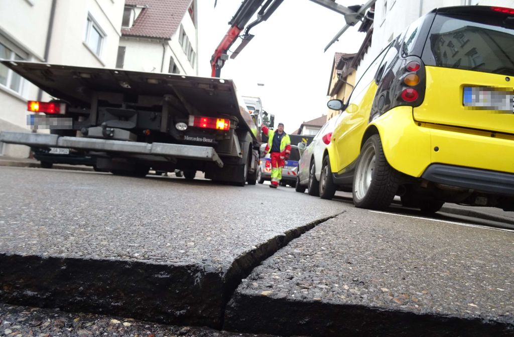 Nach dem Wasserrohrbruch in Stuttgart-Untertürkheim müssen Autos für Baggerarbeiten abgeschleppt werden.