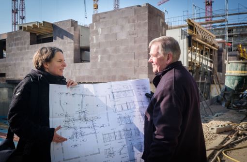 Silke Koch und Rüdiger Arendt zeigen auf der Baustelle des neuen Olga-Viertels den Plan ihres künftigen Heims. Das nimmt bereits Konturen an (siehe hinten). Foto: Lichtgut/Achim Zweygarth