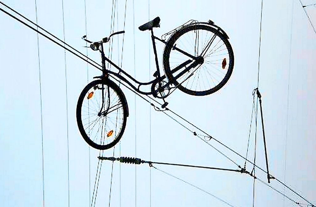 Luftiger Abstellplatz: Ein Fahrrad hängt in der Oberleitung einer Bahnstrecke in Weil am Rhein.