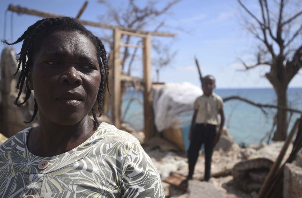 Zwei Haitianer stehen vor den Ruinen ihrer einstigen Heimat.