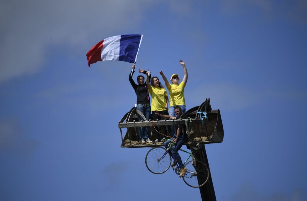 Jubeln in luftiger Höhe: diese Fans schwenken die französische Fahne auf einem Kran am Tag der ersten Etappe.