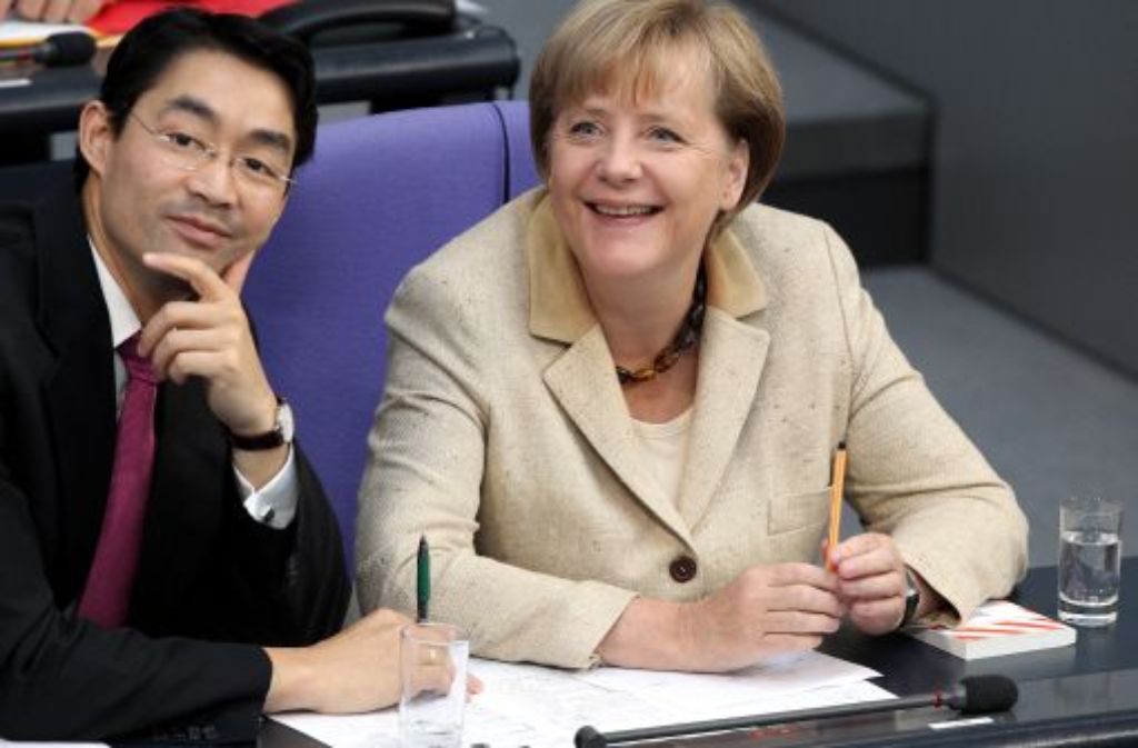 Bundeskanzlerin Angela Merkel (CDU) und Bundeswirtschaftsminister Philipp Rösler (FDP)im Deutschen Bundestag in Berlin auf das Abstimmungsergebnis.