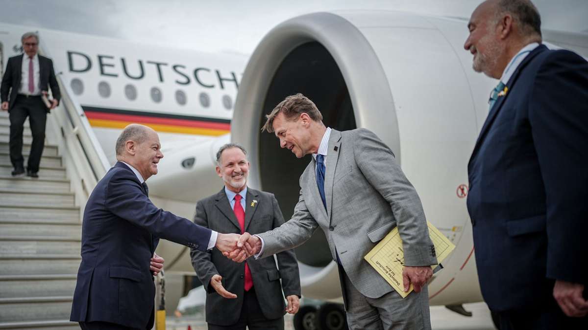 Kanzler Scholz wird auf dem Flughafen von Tel Aviv vom deutschen BOtschafter Steffen Seibert begrüßt. Rechts der israelische Botschafter in Deutschland, Ron Prosor.