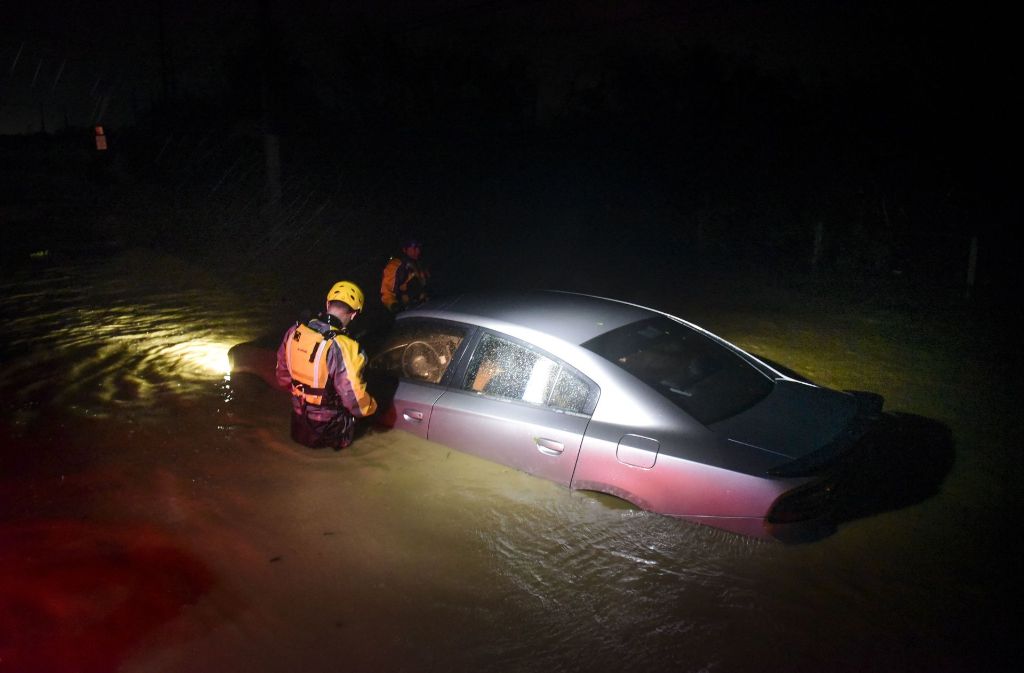Rettungskräfte überprüfen in Fajardo in Puerto Rico auf einer überschwemmten Straße ein Auto auf Hilfebedürftige.
