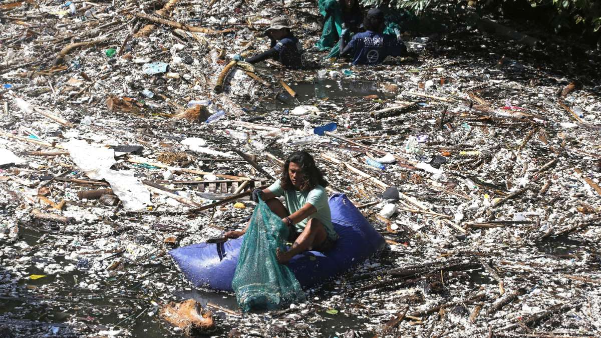 Ein Freiwilliger sammelt in Pecatu auf Bali Müll aus einem Fluss. Während der Monsunzeit sind einige Flüsse mit Plastikmüll und Unrat übersät. Lokale Behörden und Gemeinden drängen auf ernsthafte Maßnahmen zur Säuberung.