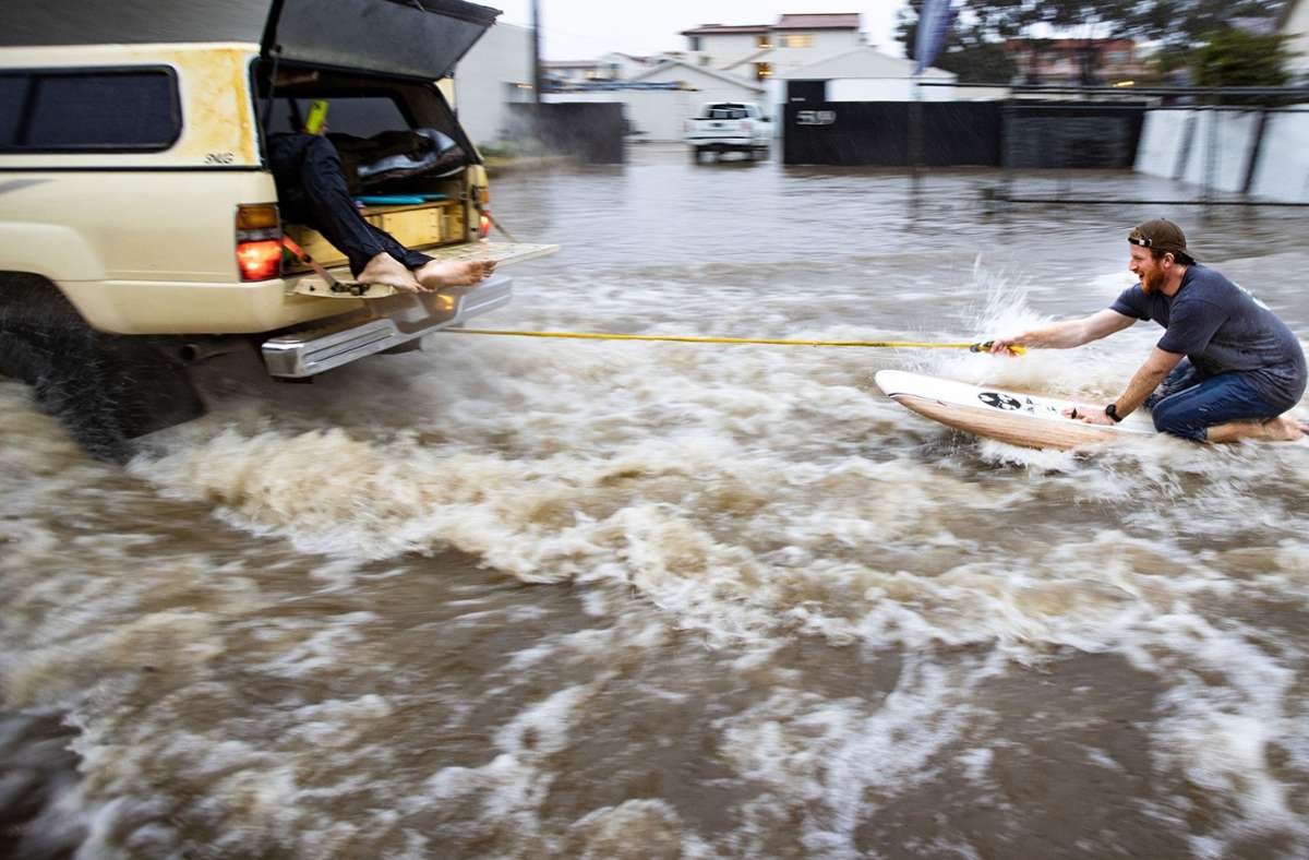 In Santa Barbara nutzte ein Mann das Hochwasser, um sich mit einem Surfbrett durch das Wasser ziehen zu lassen.