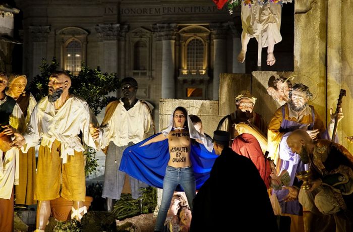 Barbusige Femen-Aktivistin in Weihnachtskrippe